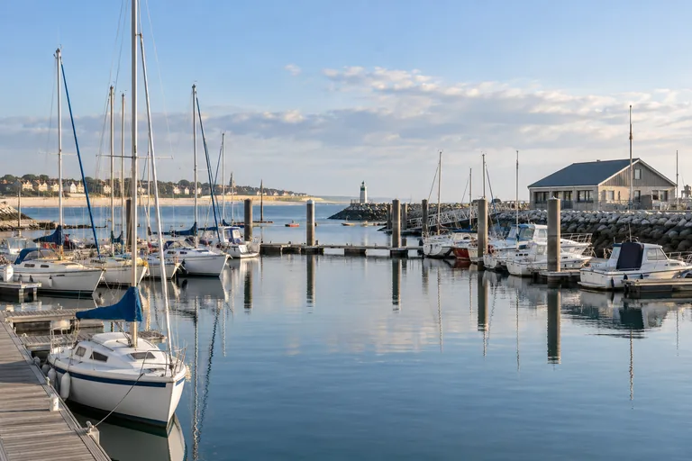 Illustration générée par IA : Voiliers et pontons dans un port normand, inspiré de Ouistreham